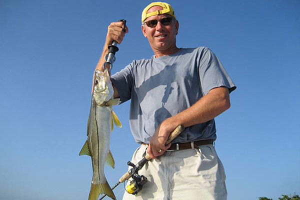 man holding a caught snook